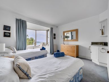 A bedroom with two beds and a dresser at Cragford Sennen Cove