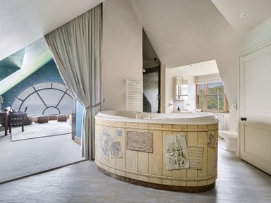A bathroom with a bathtub and window at Cragford in Sennen Cove