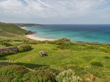 A beach and ocean view with a picnic table at Cragford in Sennen Cove