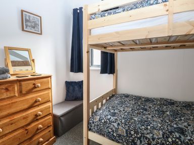 A bedroom with a bunk bed and dresser at The Long Barn in Morton on the Hill near Lenwade