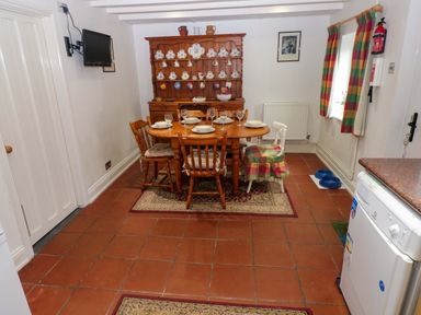 A dining room with a table and chairs at Milk Wood Cottage in Laugharne
