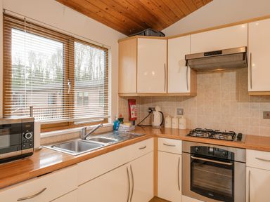 A kitchen with a sink stove oven microwave kettle and cabinets at High Tide in Rock