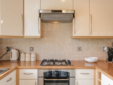 A kitchen countertop with a gas stove oven kettle ceramic containers bowl and knife set at High Tide in Rock