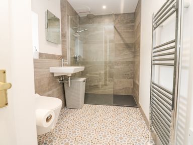 A bathroom with a toilet sink shower and towel radiator at Blacksmith Cottage in Appleby-in-Westmorland