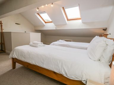 A bedroom with two single beds under skylights at Fishers Retreat in Bowness-On-Windermere