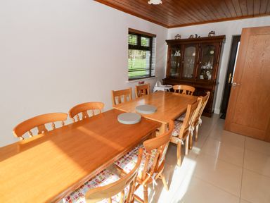 A dining room with wooden tables and chairs and a glass cabinet at Aras Iosgan in Carraroe County Galway