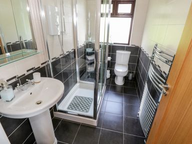A bathroom with a sink, shower enclosure, toilet, and heated towel rail at Aras Iosgan in Carraroe County Galway