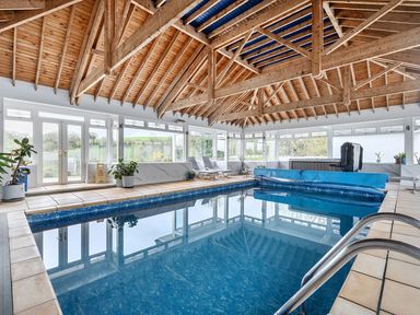 An indoor pool area with a swimming pool and deck chairs at Chapel Green Studio 2 Polgooth