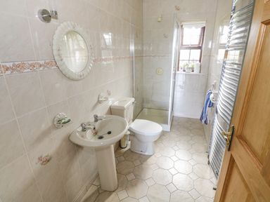 A bathroom with a pedestal sink toilet shower and window at Belladrihid Cottage in Ballysadare near Sligo County Sligo