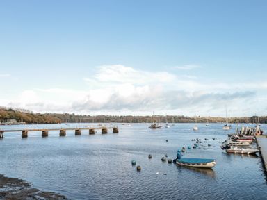 A river with boats and a pier at Cowslip Barn in Cornworthy near Dittisham