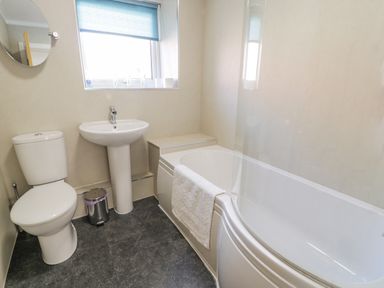 A bathroom with a toilet a sink and a bathtub with a towel at Snowdon View in Llanberis