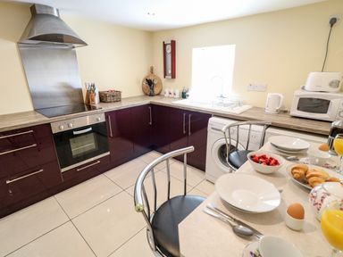 A kitchen with dark cabinets and a countertop with appliances and breakfast items at Whispering Willows - The Thatch in Carndonagh County Donegal