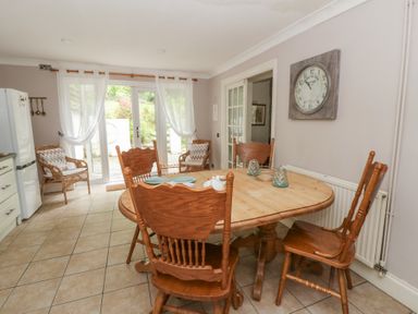 A dining room with a round table and chairs at Teifi House in Cilgerran near Cardigan