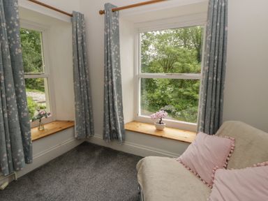A sitting room with windows and a sofa at Teifi House in Cilgerran near Cardigan