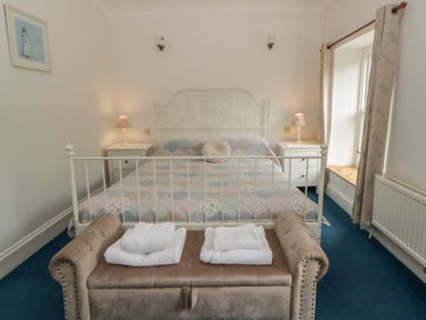 A bedroom with a bed and bench at Teifi House in Cilgerran near Cardigan