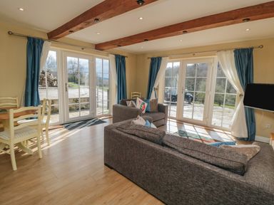 A sitting room with sofas dining table large windows and visible outdoor area at Ericas eaven in Farndale near Kirkbymoorside