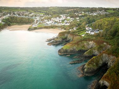 A coastal village with sandy beaches cliffs and houses surrounded by trees at Fern Cottage in Aberporth