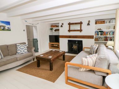 A living room with a sofa and coffee table at Fern Cottage in Aberporth