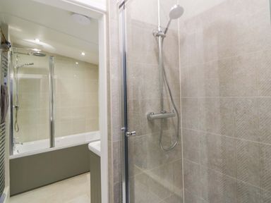A bathroom with a shower and bathtub at Fern Cottage Aberporth