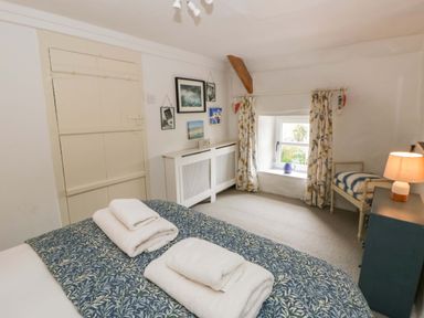 A bedroom with a bed and towels on it at Fern Cottage in Aberporth
