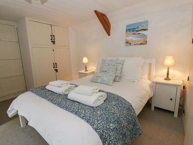 A bedroom with a bed and bedside tables at Fern Cottage in Aberporth