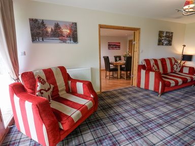 A living room with red and white striped sofas and a plaid carpet at Pond Farm Woodlands in Ugthorpe