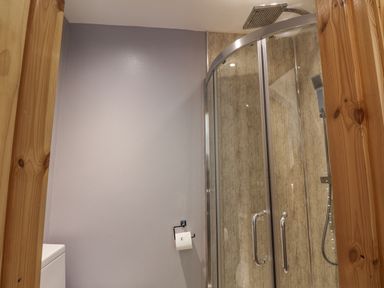 A bathroom with a shower enclosure a toilet and a toilet roll holder at Pond Farm Woodlands in Ugthorpe
