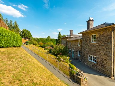 A stone house with a pathway and garden area at Old Rectory House in Caersws