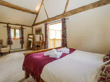 A bedroom with a bed and a dressing table at The Hayloft in Bleddfa near Knighton