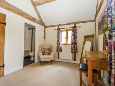 A bedroom with an armchair and table at The Hayloft in Bleddfa near Knighton