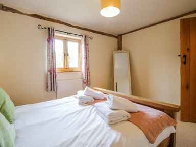 A bedroom with a bed and towels at The Hayloft in Bleddfa near Knighton