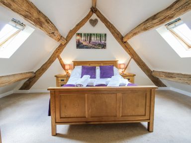A bedroom with a bed and wooden beams at The Hayloft in Bleddfa near Knighton