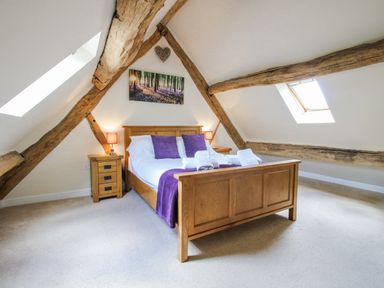 A bedroom with wooden beams and a double bed at The Hayloft in Bleddfa near Knighton