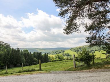 A landscape view with trees and hills at The Hayloft in Bleddfa near Knighton
