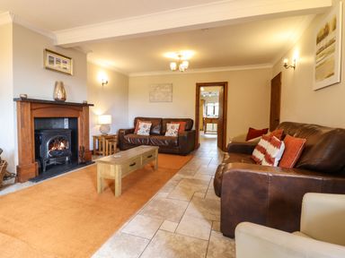 A living room with two brown leather sofas a coffee table and a fireplace at Ty Newydd in Llangadfan