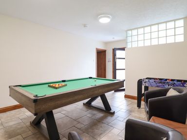 A game room with a pool table a foosball table and chairs at Ty Newydd in Llangadfan