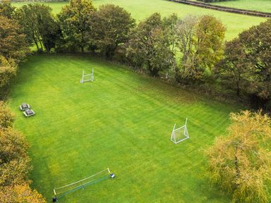 An outdoor area with goal posts and benches at Ty Newydd in Llangadfan