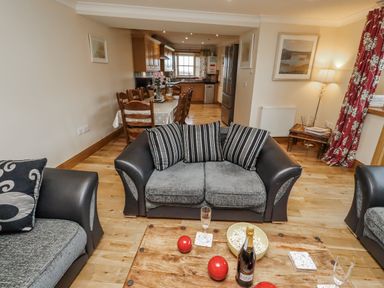 A living room with a coffee table and kitchen in High Hemmel House Embleton