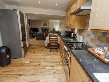 A kitchen with appliances and a dining area at High Hemmel House in Embleton