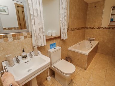 A bathroom with sink, toilet, and bathtub at High Hemmel House in Embleton