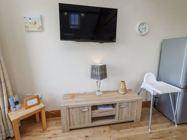 A living room with a television and a coffee table at Home Stead Cottage in Embleton