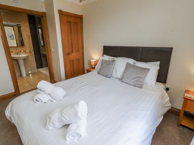 A bedroom with a bed and a bathroom view at Home Stead Cottage in Embleton