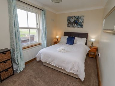 A bedroom with a bed and window at Home Stead Cottage in Embleton