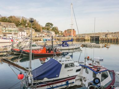 A harbor with several boats and buildings in the background at Tiggy Winkle in St Merryn near Padstow