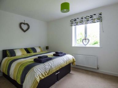A bedroom with a double bed and folded towels on the bed at Tehidy in Charlestown