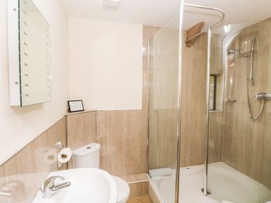 A bathroom with a sink a toilet and a glass shower enclosure at The Long Barn in Hasguard near Little Haven