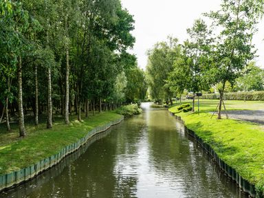 A canal with trees on both sides and grassy banks at Grafton Mill in Grafton Flyford near Pershore