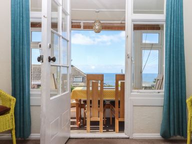 A dining room with a view of the sea at Highdown Bigbury on Sea near Modbury