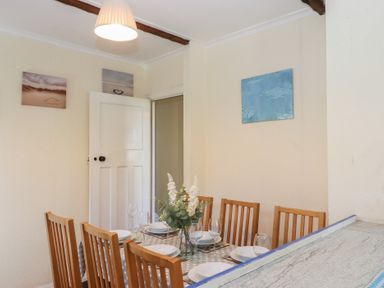 A dining room with a table set for dinner at Highdown Bigbury on Sea near Modbury