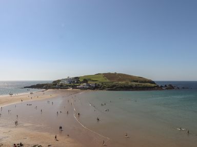 A beach with people walking on sand near the sea at Highdown in Bigbury on Sea near Modbury